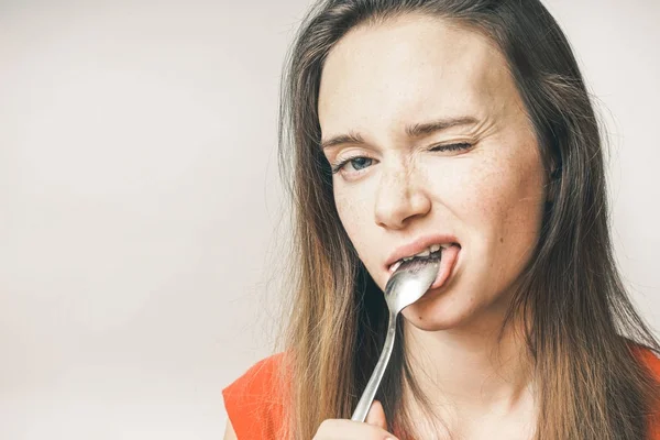 Mulher com raiva comendo colher. a menina pisca para a câmera, isolado — Fotografia de Stock