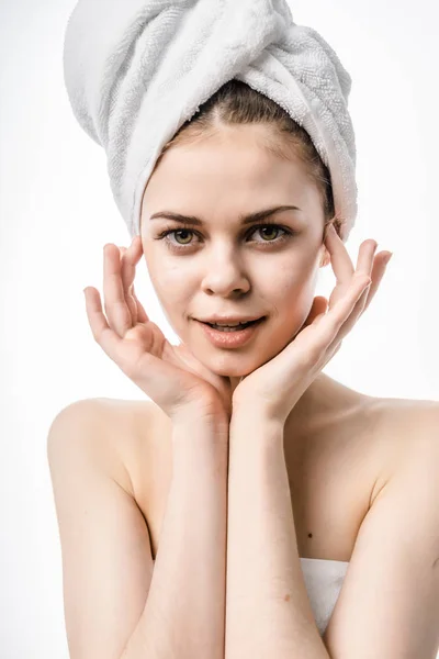 Bela jovem com pele limpa, com uma toalha branca na cabeça, olha para a câmera — Fotografia de Stock