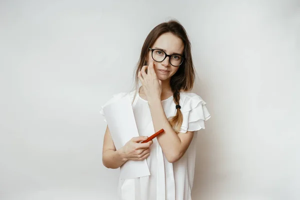 Én egy fiatal lány szemüveg és egy fehér póló gazdaság dokumentumok és egy toll — Stock Fotó