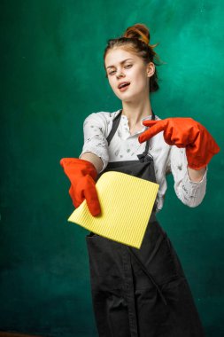 iyi bir kız temizlik yapmak için gidiyor. büyük bir önlük ve turuncu lastik eldiven giymiş kadın