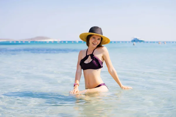 年轻女孩游泳, 海滩时间, 游艇模糊, 在一个时髦的泳装 — 图库照片