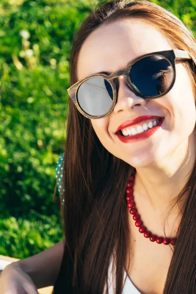 Close up volto donna in occhiali da sole, occhiali di legno, sorriso bianco — Foto Stock