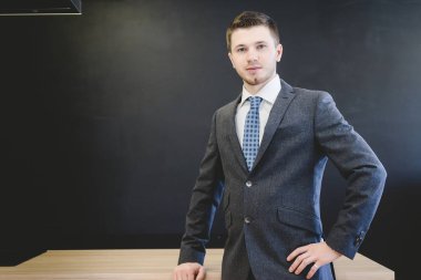 siyah bir zemin üzerine bir masada poz elbiseli emin başarılı adam