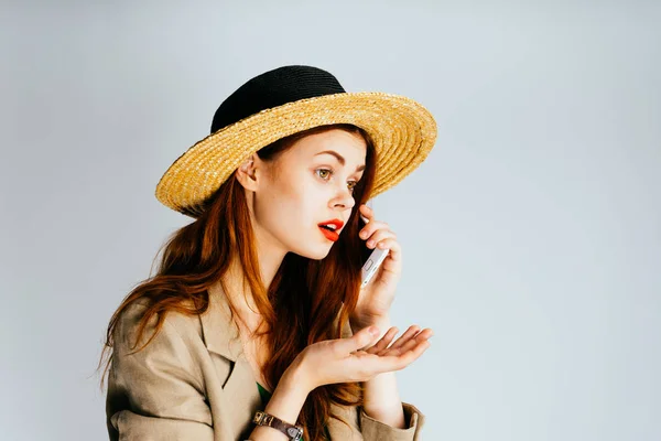 Ragazza elegante in un cappello di paglia, con rossetto rosso, parlando al telefono — Foto Stock