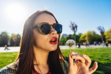 Mutlu gülümseyen komik surat kız darbe karahindiba, yaz güneş gözlüğü, günbatımı