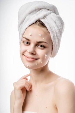 güzel genç kız başında, yüzündeki yararlı bir krem, beyaz bir havlu ile gülümseyen