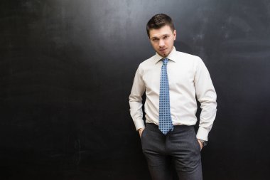 siyah bir arka plan üzerinde poz elbiseli başarılı kendine güvenen genç adam