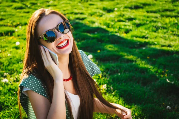 Счастливые зубы здоровья женщина улыбается в солнечных очках, держит телефон — стоковое фото
