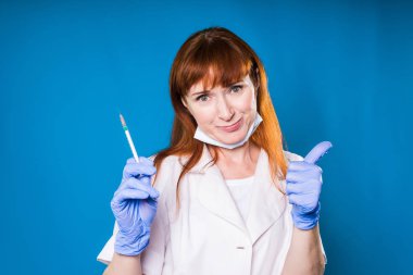 Yetişkin deneyimli Kızıl saçlı kadın doktor el gösteren parmağını şırıngada gidiyor