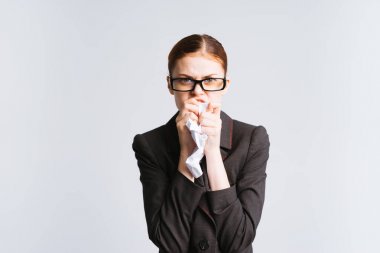 sıkı bir kızıl saçlı kız gözlük ve siyah bir tıbbi takım elbise ile beyaz kağıt yiyor