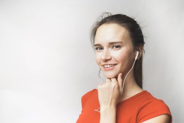 Gülümseyen kulaklık, teen, turuncu bir t-shirt ile mutlu kadın