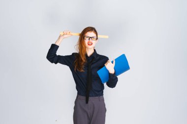 şık bir hoşnutsuz Kızıl saçlı kız gözlüklü karanlık giyim elinde bir cetvel ve belgeleri içeren bir klasör