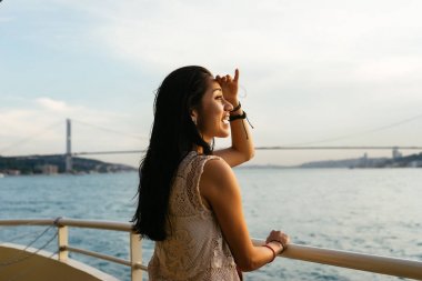 Gezi teknesinde arayan genç kız Gezgin günbatımı, cruise, sürpriz Uzaklik bakarak