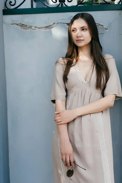 Encantadora menina bonita em vestido bege posando contra a parede — Fotografia de Stock