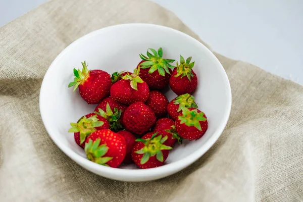 Fresas frescas crudas y saludables dieta fruta en plato, aislado en blanco, ver arriba, plano de cerca, copyspace para el texto, frame.Village lienzo rústico, comida campestre — Foto de Stock