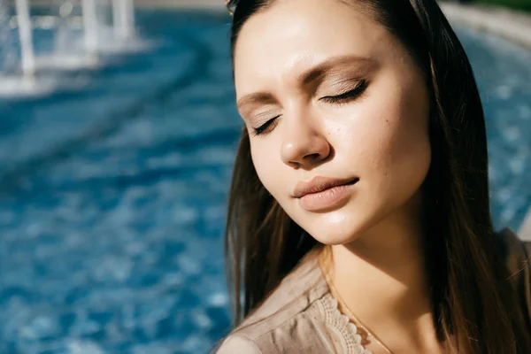Nádherný atraktivní dívka má paprsky slunce na pozadí modré vody — Stock fotografie