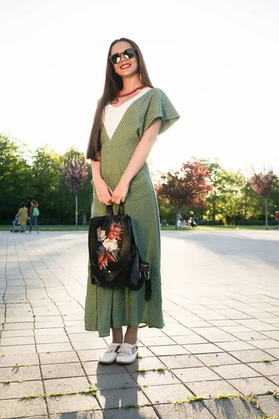 Fashion street style woman with bag in hand,sunset