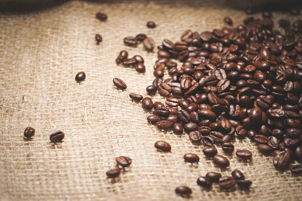 На тканиною бежева лежать зерен ароматної кави Бразильський — стокове фото