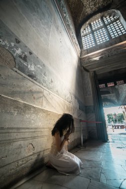 Umut, üzgün, kayıp kız Tapınağı ilahi ışık ışınları çökmüş dua ediyor.