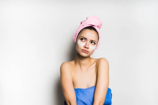 Красивая молодая девушка с розовым полотенцем на голове задумчиво глядя вверх — стоковое фото