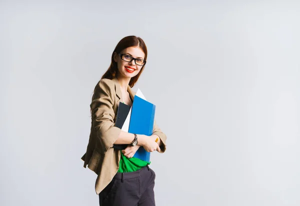 Stylisches rothaariges Mädchen mit Brille und grüner Jacke hält einen Ordner mit Dokumenten in der Hand und lächelt — Stockfoto