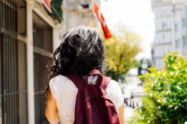 Kadın geri çekip, Türkiye bayrağı arka üzerinde sırt çantası ile