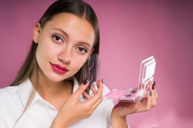 Beyaz gömlekli güzel çekici kız ile sahte kirpik ambalaj elinde tutan