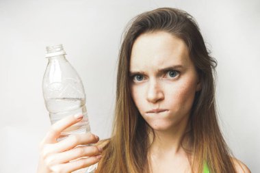 Kameraya bakarak bir şişe temiz su ile onun elinde tutan kızgın genç kız