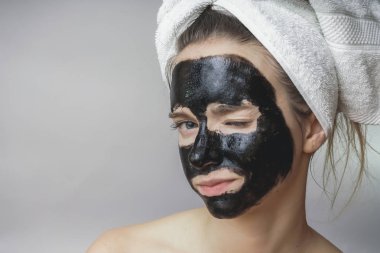 Gülümseyen mutlu kadın cilt bakım siyah mack face.moisturizer için uygulanan