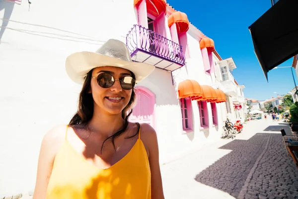 Mujer turista viajando en sombrero de sol y gafas en vacaciones de verano caminando en la ciudad vieja Alacati, Cesme, Turquía —  Fotos de Stock