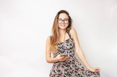 Cep telefonu, gözlüklü ve şık bir elbise olumlu gülümseyen kız tutar