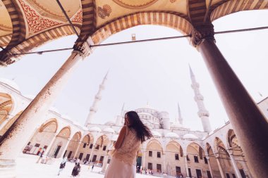 Caminin mavi arka plan üzerinde başörtüsü duran genç kadın gezgin. Yaz tatillerinde seyahat