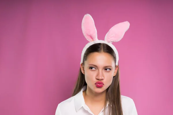 Una giovane ragazza divertente in camicia bianca e orlo a forma di orecchie di coniglio contorce un viso divertente — Foto Stock