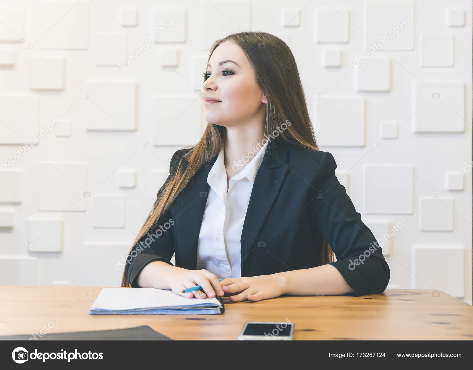 Confident successful young girl in a black suit sitting in the office at  the table and thinking about the project Stock Photo by ©mne_len 173267124