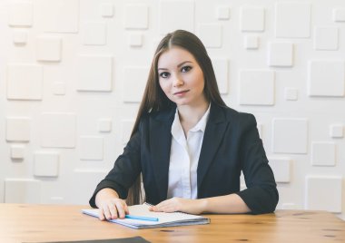 ahşap bir masa ofiste oturmuş Siyah takım elbiseli başarılı modern genç kız