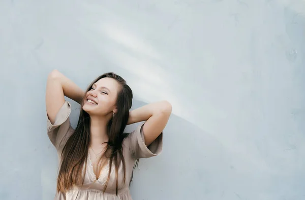 Joven mujer brillante disfrutar, feliz sonrisa, copyspace, contra el fondo de una pared de luz — Foto de Stock