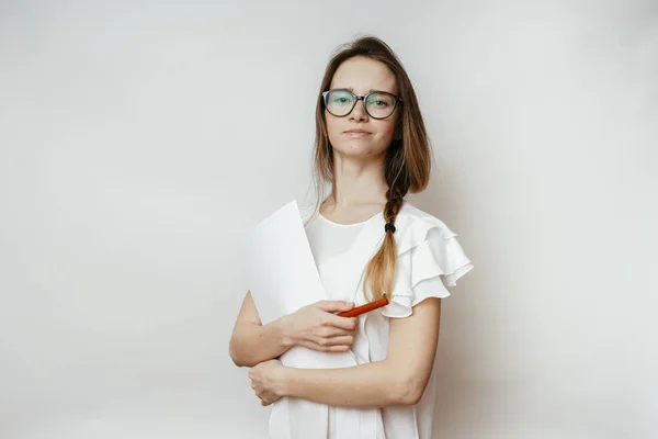 Nettes junges Mädchen mit Brille und weißem T-Shirt, das Dokumente hält, posiert, in die Kamera blickt — Stockfoto