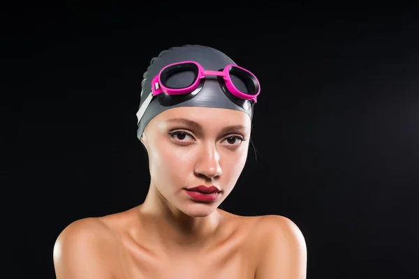 Jovem nadador forte confiante em uma touca de natação e óculos olha para a câmera — Fotografia de Stock