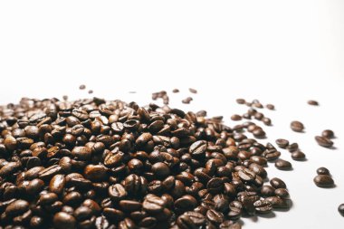 Beyaz bir arka plan üzerinde koyu kahverengi tahıl kokulu Brezilyalı kahve yalan