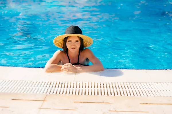 Donna in acqua si trova sul bordo della piscina — Foto Stock