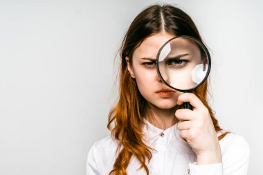kızgın genç kız Beyaz gömlekli Büyüteç görünüyor