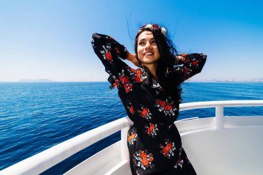 Yelkenli üzerinde mutlu kadın turist sahiptir hava ve güneş, mavi Denizi çevresinde
