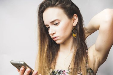 Mobile ile üzgün kız. güzel küpe ciddi kız telefonda görünüyor