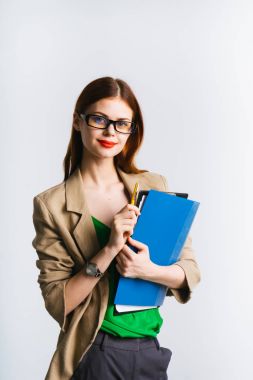 Kızıl saçlı kız gözlüklü bir klasör belgeler ve sevimli kameraya gülümseyen tutuyor