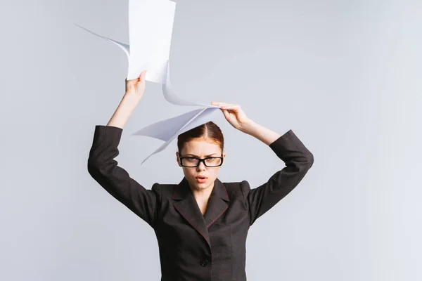 Müde, traurige Geschäftsfrau in Brille und Anzug hält Dokumente über den Kopf — Stockfoto