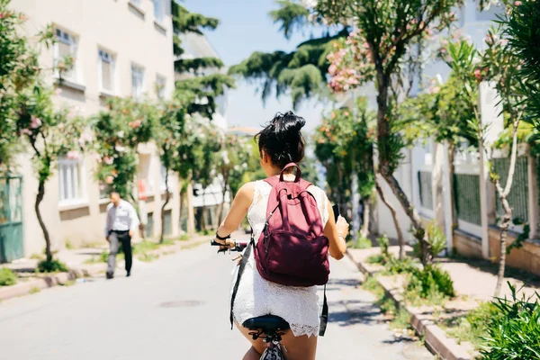 Bakifrån kvinna på cykel. Varm sommardag, utomhusaktiviteter — Stockfoto