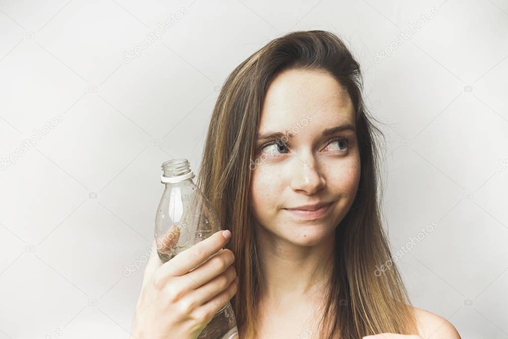 Happy woman with bottle looking right. beautiful girl with long hair, isolated