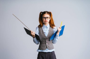 gözlük ile üzgün Kızıl saçlı kız öğrenci belgeleri ve cetvel klasörlerle tutar