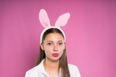 Beyaz gömlekli, şirin genç kız tavşan kulakları sakız bir balon şişirmek çalışırken başında şeklinde bir RIM ile