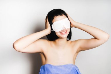 gülümseyen kız siyah saçlı kapalı kulakları, onun gözleri beyaz maske